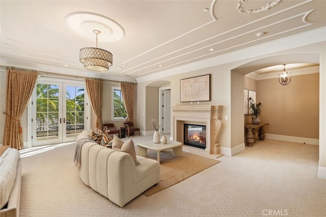 carpeted living room with french doors and ornamental molding