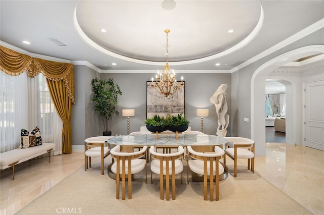 dining area featuring an inviting chandelier, crown molding, and a tray ceiling