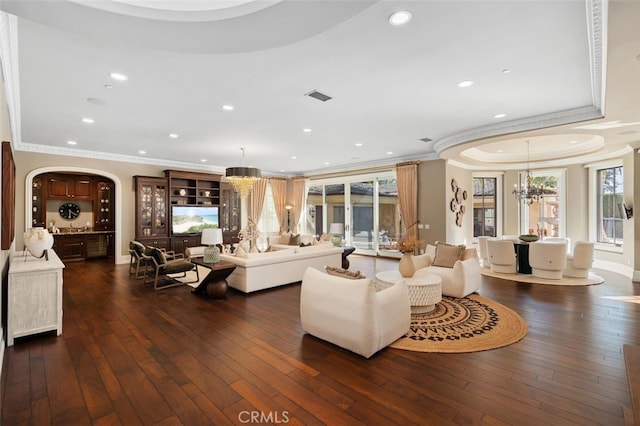 living room with dark hardwood / wood-style floors, a healthy amount of sunlight, and crown molding