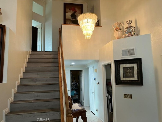 staircase with tile patterned floors and a chandelier