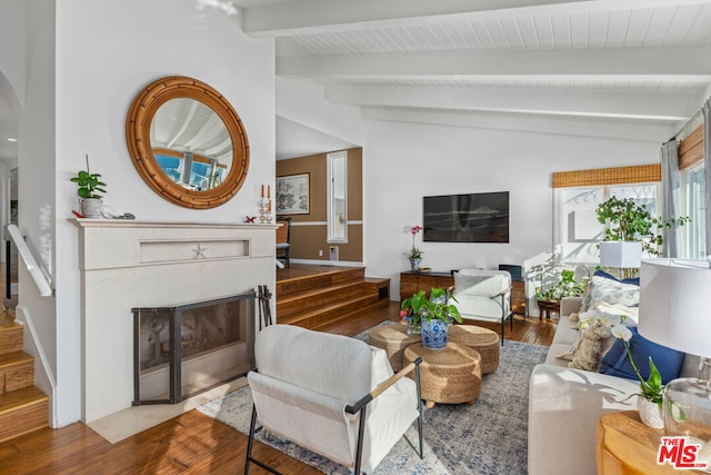 living room with wood-type flooring and vaulted ceiling with beams