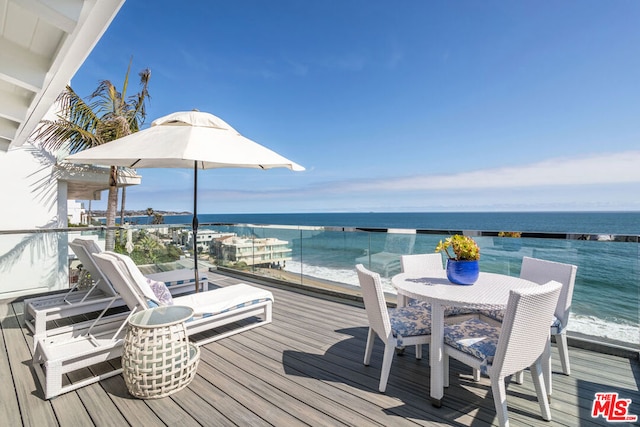 wooden deck with a water view and a view of the beach