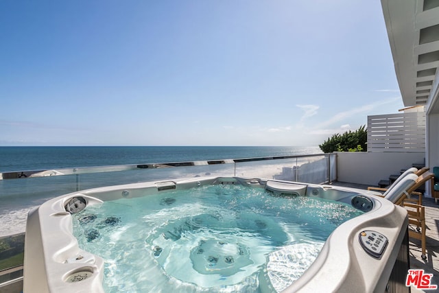 view of swimming pool with a water view and a hot tub