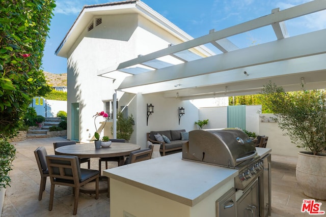 view of patio featuring area for grilling, a pergola, and grilling area