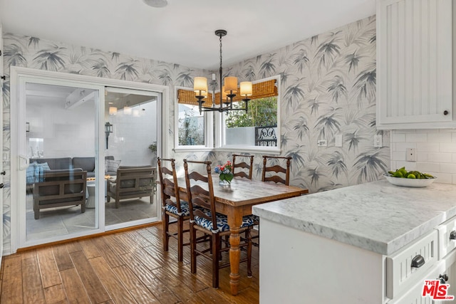 dining room featuring hardwood / wood-style floors, breakfast area, and an inviting chandelier