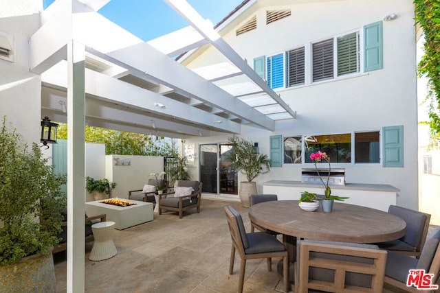 view of patio / terrace with a pergola and a fire pit