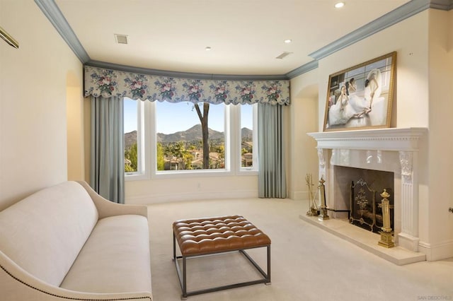 living area with a mountain view, carpet floors, crown molding, and a high end fireplace