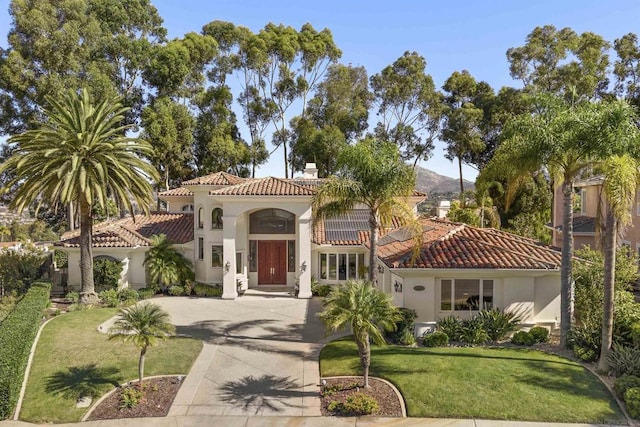 mediterranean / spanish house with a front lawn