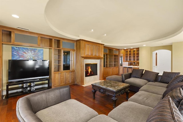 living room with dark hardwood / wood-style floors and a raised ceiling