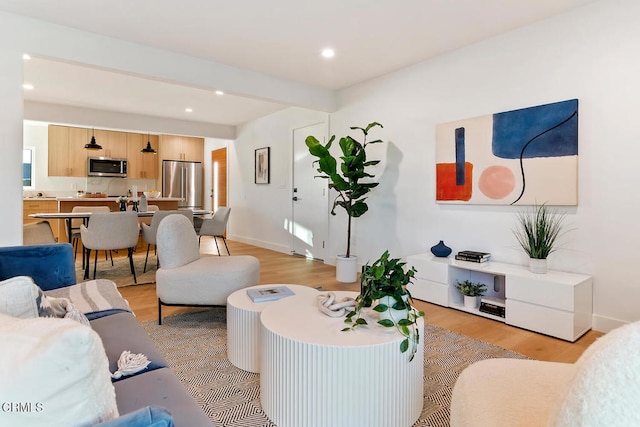 living room with light hardwood / wood-style floors and beam ceiling