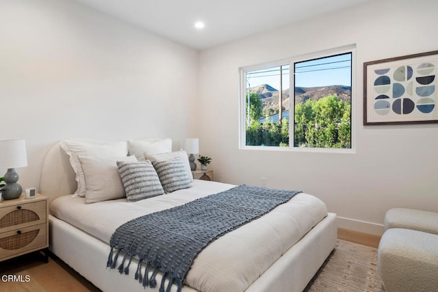 bedroom with hardwood / wood-style floors and a mountain view