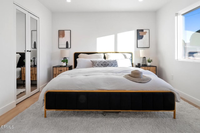 bedroom with french doors and light hardwood / wood-style floors