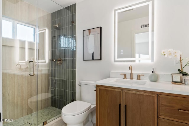 bathroom featuring vanity, an enclosed shower, and toilet