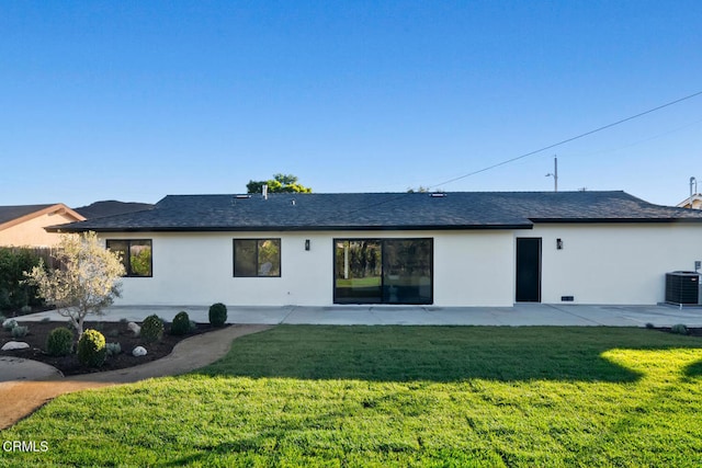 rear view of property with a lawn, cooling unit, and a patio area