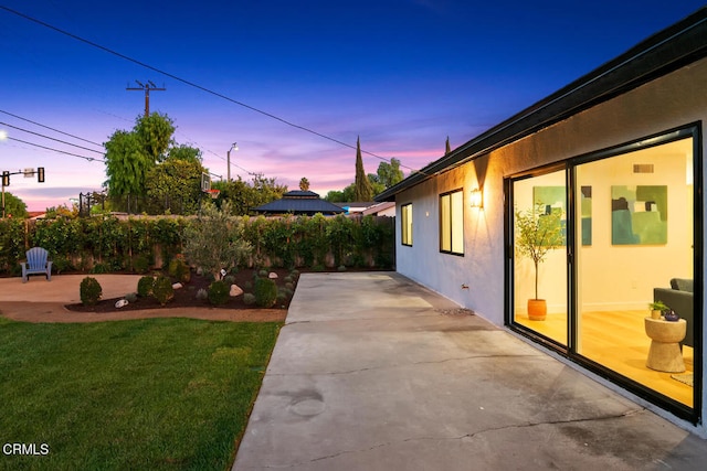 yard at dusk with a patio area