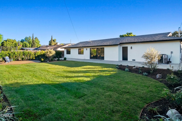 rear view of house with a lawn, central AC, and a patio