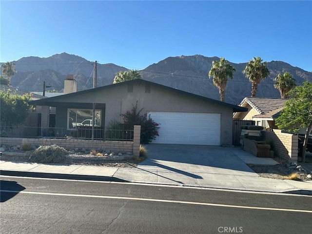 view of front of home with a mountain view and a garage