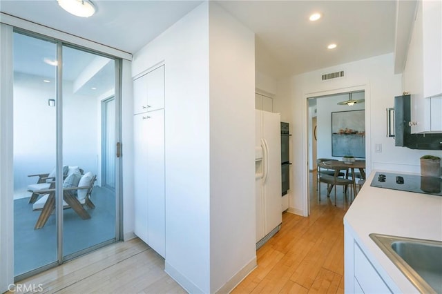 hallway featuring sink and light wood-type flooring