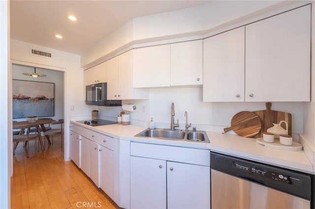 kitchen with white cabinetry, sink, light hardwood / wood-style flooring, and black appliances