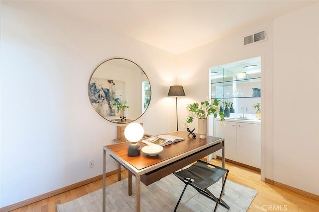 home office featuring sink and light hardwood / wood-style flooring