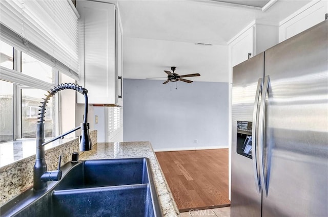 kitchen with ceiling fan, sink, wood-type flooring, white cabinets, and stainless steel fridge with ice dispenser