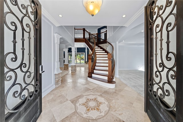 foyer with ornate columns and ornamental molding