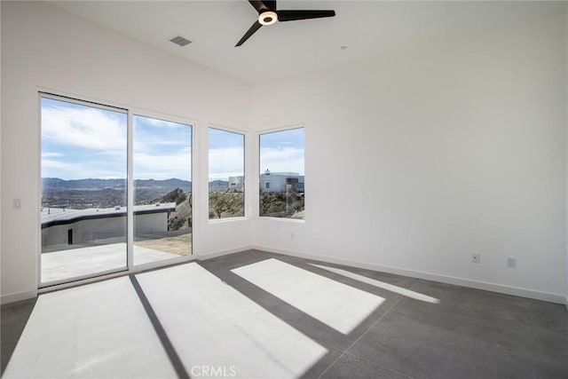 empty room featuring a mountain view and ceiling fan