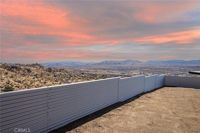 yard at dusk featuring a mountain view