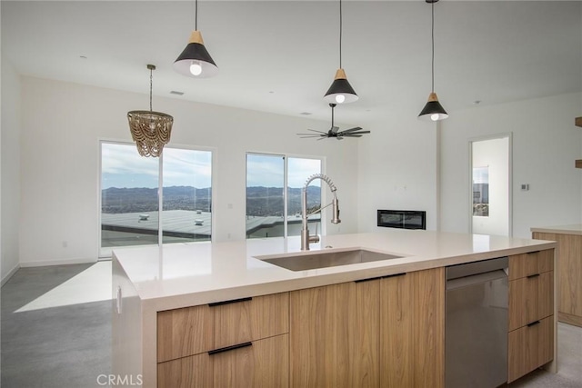 kitchen with dishwasher, light brown cabinets, a mountain view, a kitchen island with sink, and sink