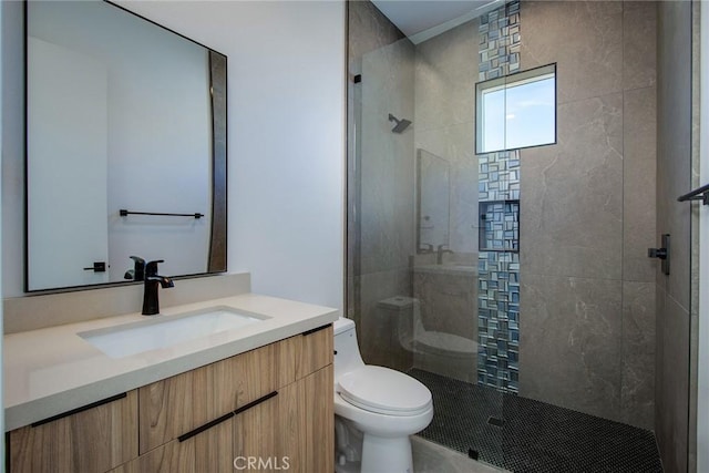 bathroom featuring tiled shower, vanity, and toilet