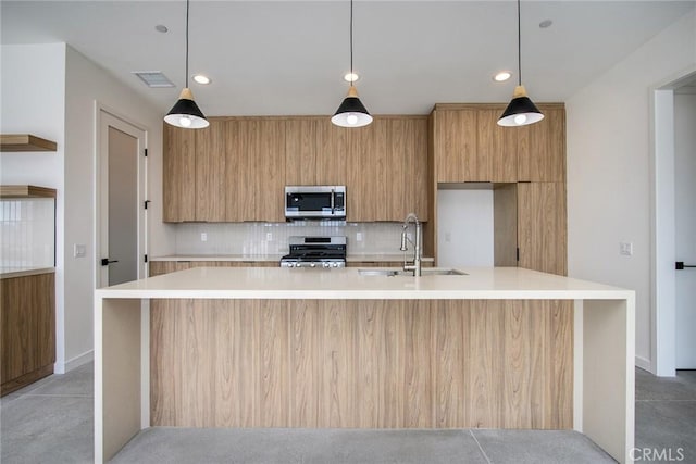 kitchen with pendant lighting, stainless steel appliances, and a kitchen island with sink