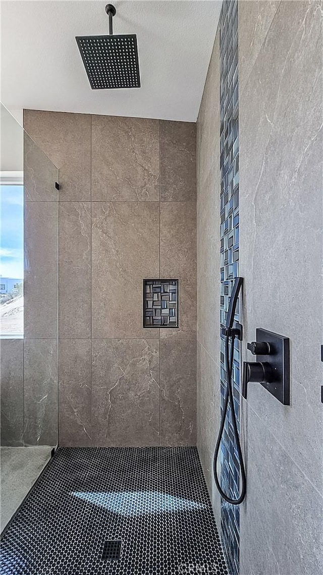 room details with a textured ceiling and tiled shower