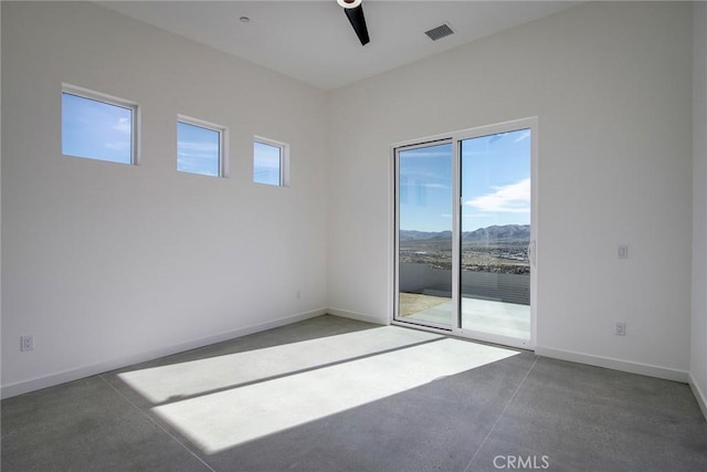 spare room featuring plenty of natural light, ceiling fan, and a mountain view