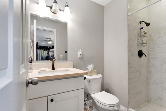bathroom featuring a tile shower, vanity, and toilet