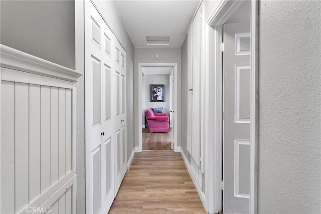 hallway with light hardwood / wood-style flooring