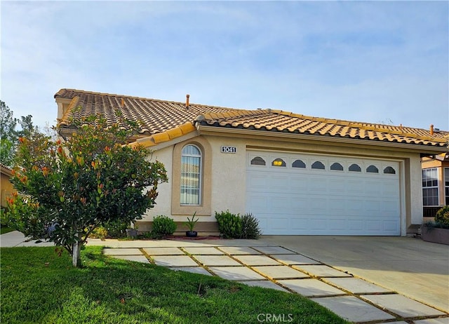 mediterranean / spanish-style house with a garage