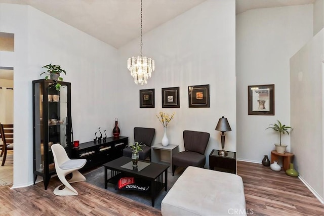 living room featuring hardwood / wood-style floors, high vaulted ceiling, and a chandelier