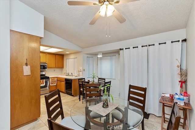 tiled dining area featuring a textured ceiling, ceiling fan, sink, and lofted ceiling