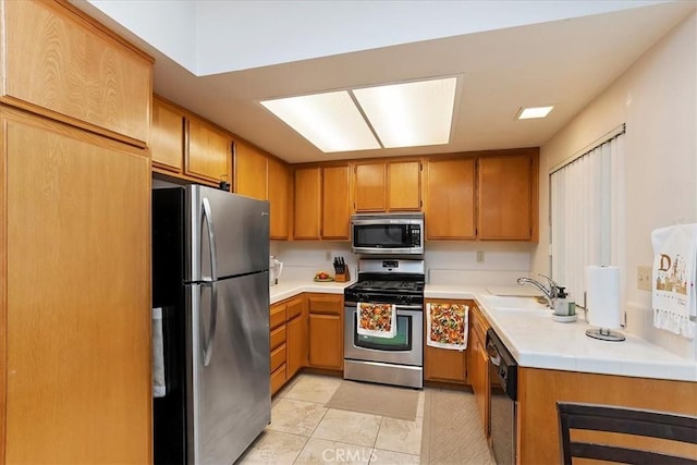 kitchen with appliances with stainless steel finishes, light tile patterned floors, and sink