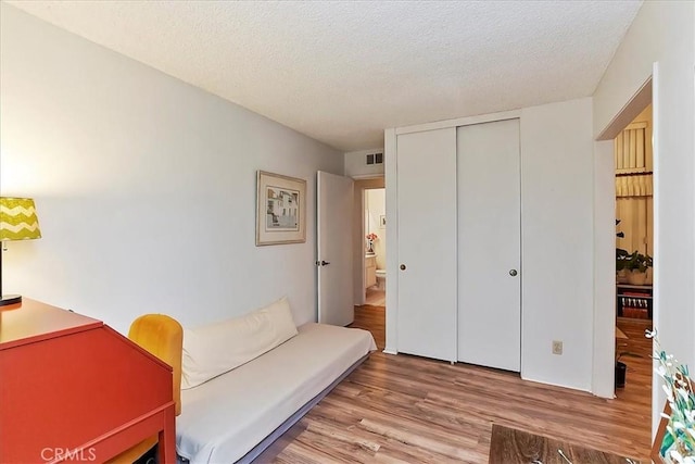 sitting room with wood-type flooring and a textured ceiling