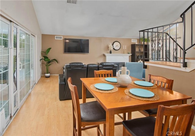 dining room featuring light hardwood / wood-style floors and lofted ceiling