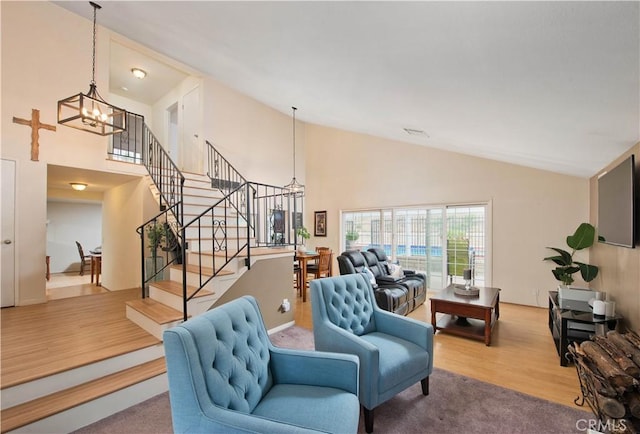 living room with hardwood / wood-style floors, high vaulted ceiling, and a chandelier