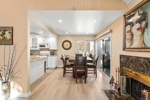 dining area featuring a fireplace and light hardwood / wood-style flooring