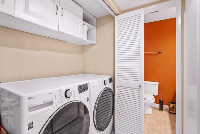 laundry area featuring cabinets, independent washer and dryer, and light tile patterned floors