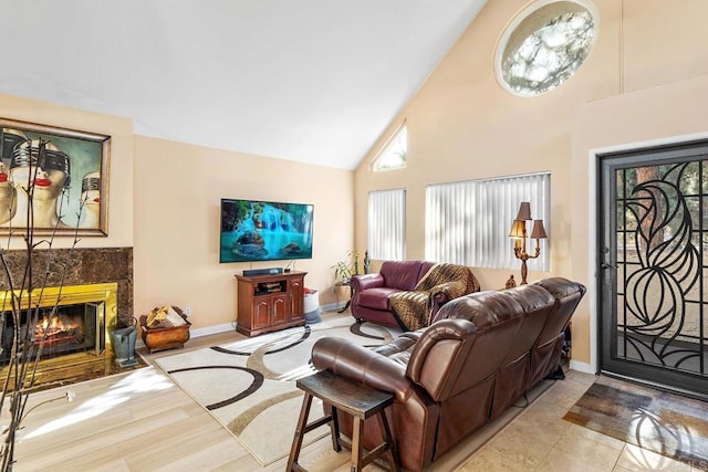 living room with a fireplace, light hardwood / wood-style floors, and high vaulted ceiling