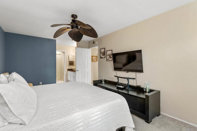 bedroom with light colored carpet, ensuite bath, and ceiling fan