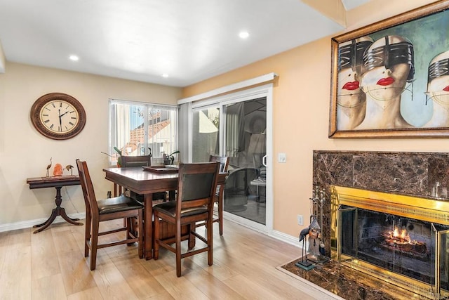 dining area featuring a premium fireplace and light wood-type flooring