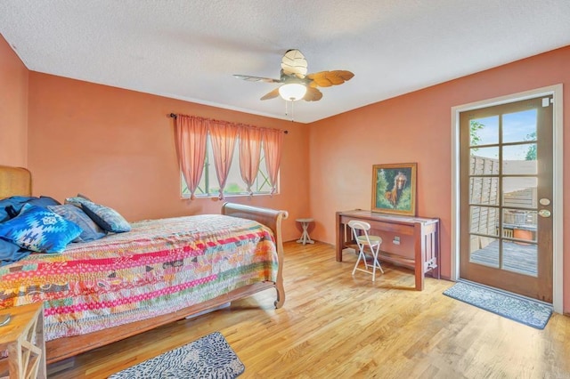 bedroom with a textured ceiling, wood-type flooring, and ceiling fan