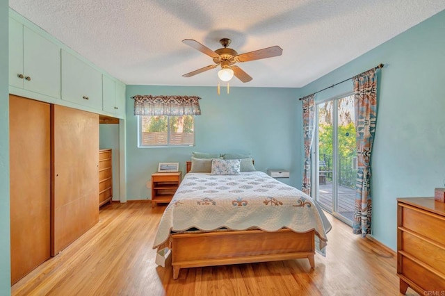 bedroom featuring multiple windows, access to outside, and light wood-type flooring