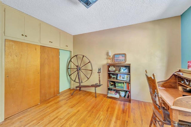 office space with light hardwood / wood-style floors and a textured ceiling